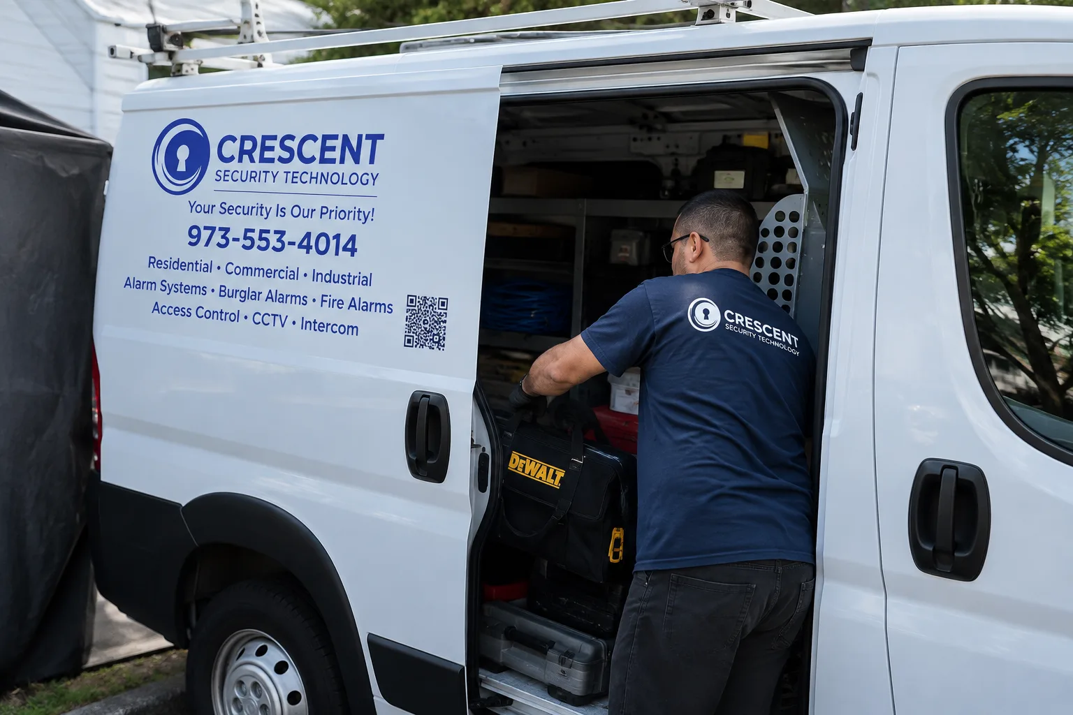 A Crescent Security Technology technician taking tools from the company service van
